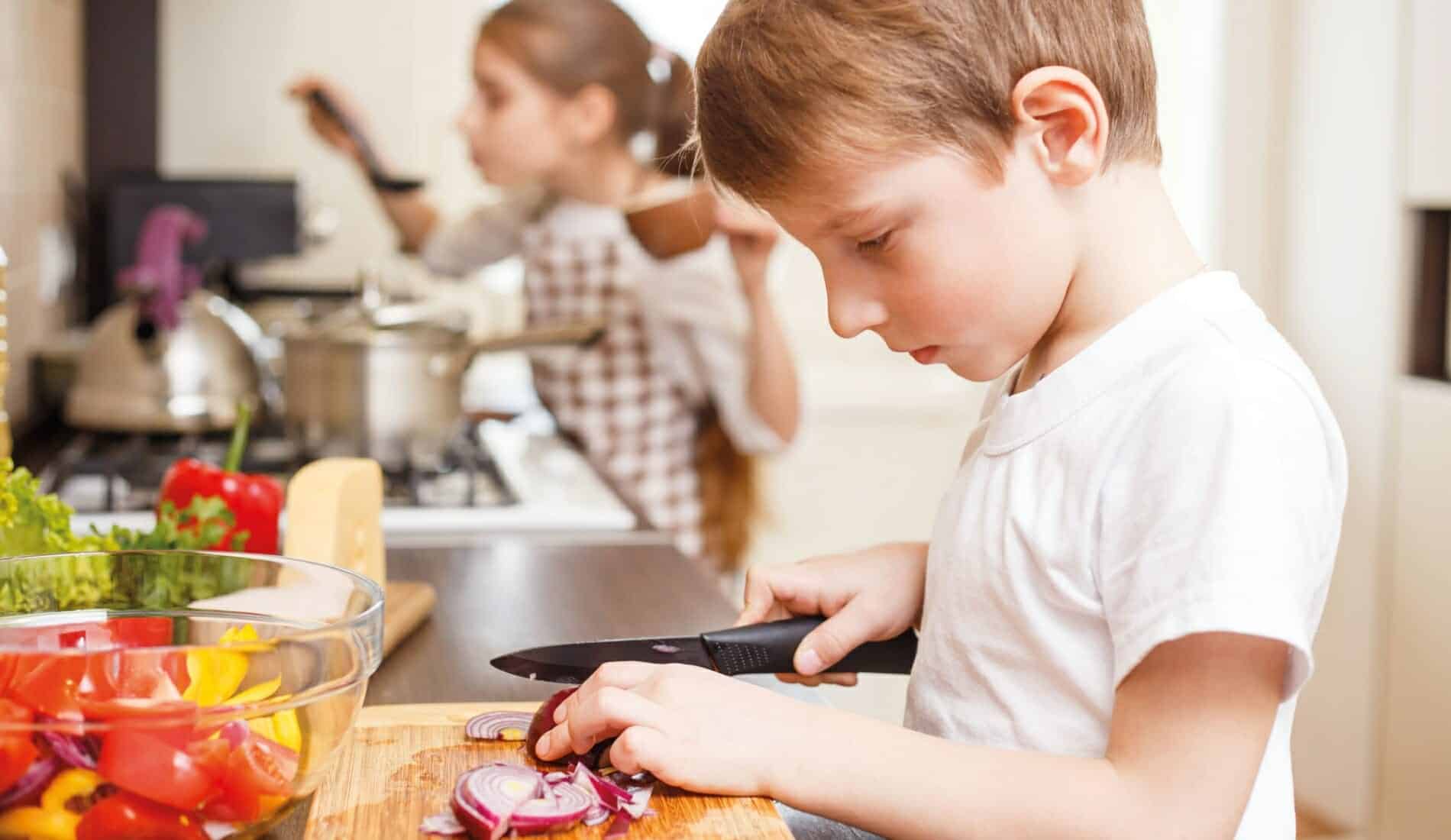 Nachhaltig kochen mit Kindern Kind schneidet Zwiebel