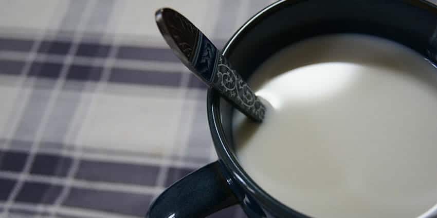 Eine Tasse Milch auf dem Frühstückstisch