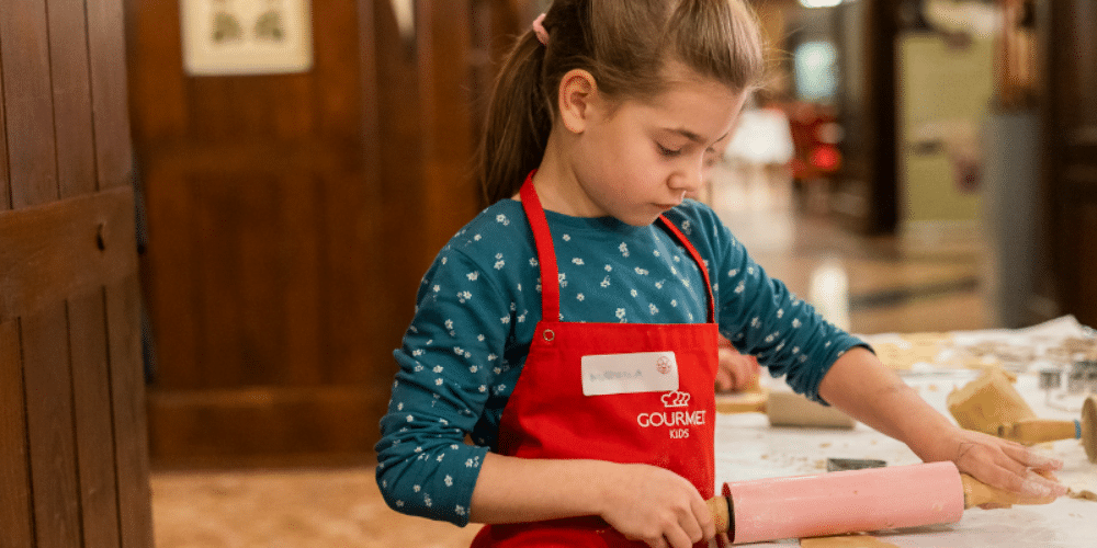 Kind rollt Keksteig aus bei der Gourmet Backwerkstatt